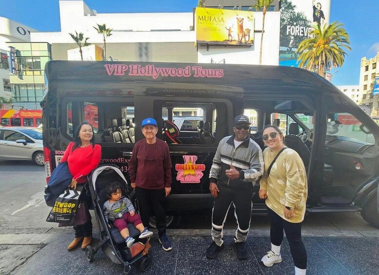 A group of people standing in front of a black van with 'VIP Hollywood Tours' written on it. 2