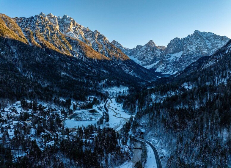 A snow-covered mountain valley with a winding road and a small settlement. 3