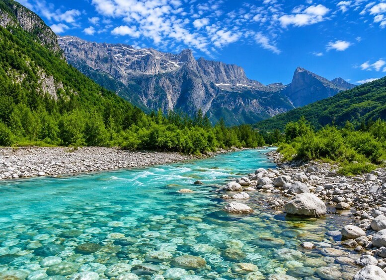 A clear mountain river with rocky banks and lush greenery. 1