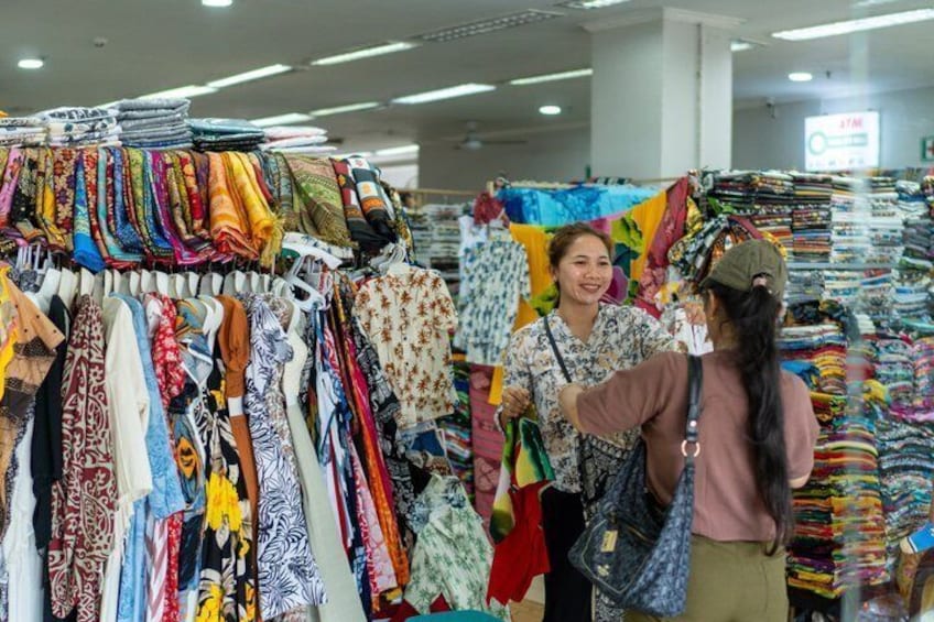 A clothing store with various fabrics and garments on display. 3