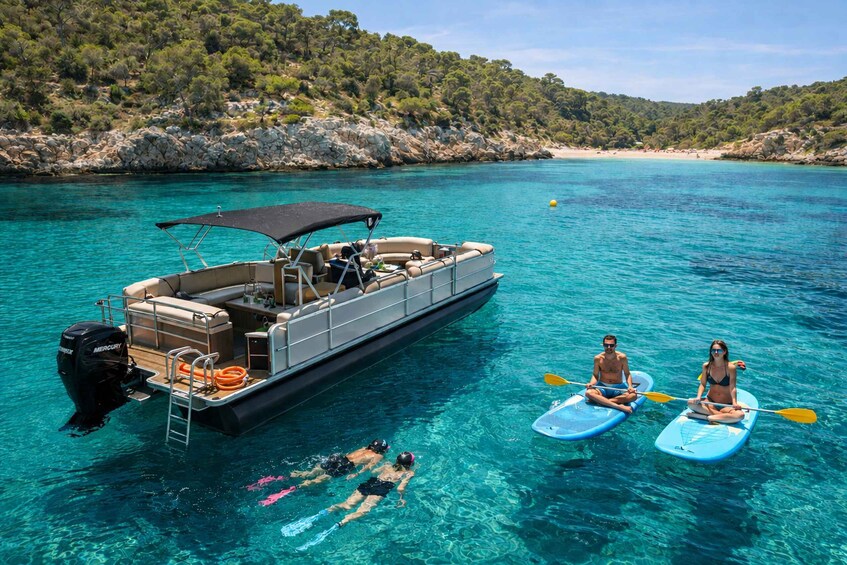 A boat with a covered deck, two kayaks, and people kayaking. 3