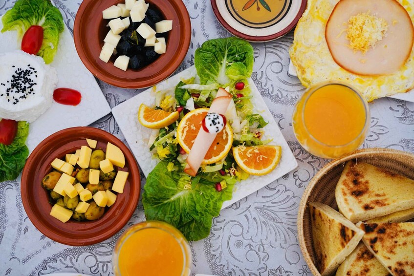 A variety of dishes including a salad with pomegranate seeds, cheese, and a plate of eggs. 4