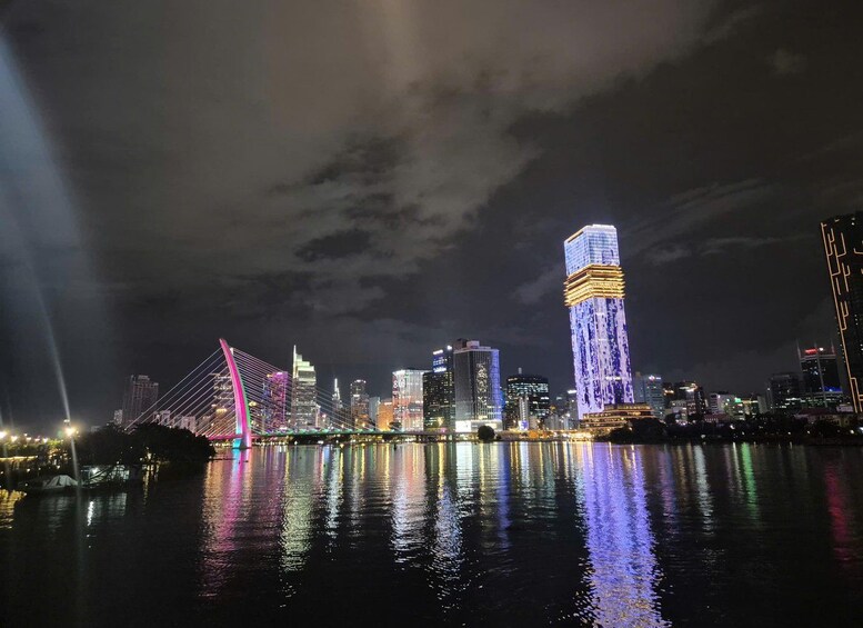 A city skyline at night with illuminated buildings and a bridge reflecting on the water. 5