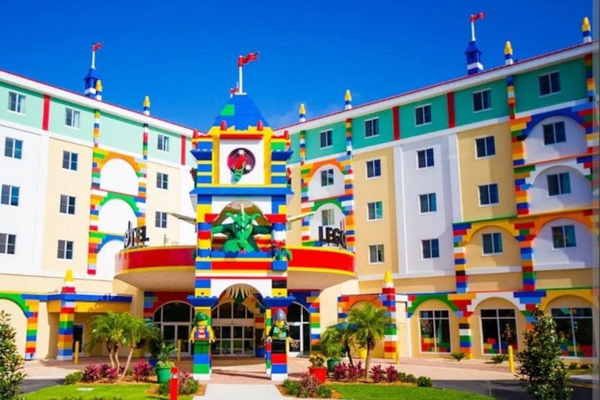 A colorful building with a LEGO-like facade, a central archway, and a flag on top. 3