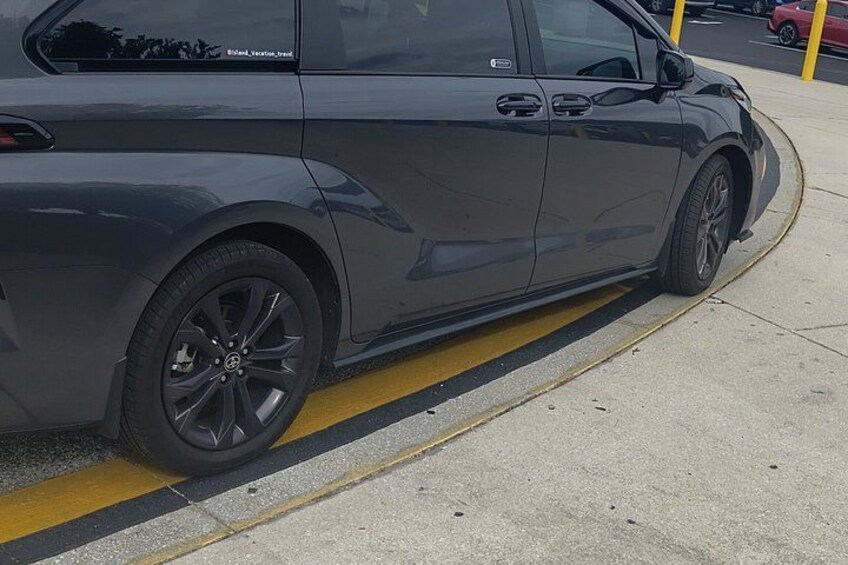 A gray car parked next to a yellow curb. 5