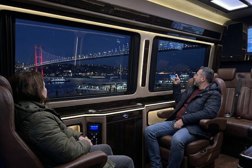 A person taking a photo of a bridge at night. 4