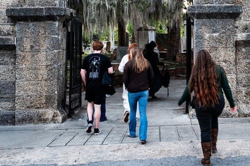 A group of people walking through a stone gate. 3