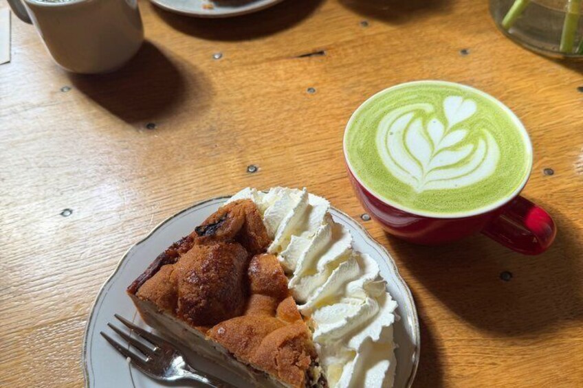 A plate of pie with whipped cream and a cup of coffee with latte art. 3