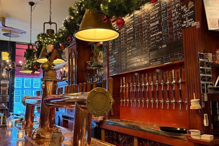 A bar with a brass tap, a Christmas tree, and a menu board. 5