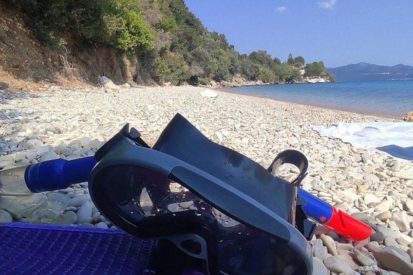 A beach with pebbles, a blue and red object, and a clear sky. 5