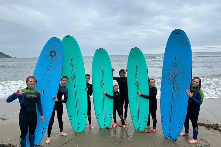 A group of people holding surfboards on a beach. 1