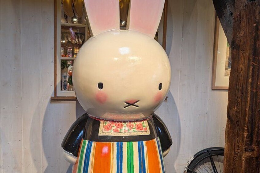 A large rabbit statue with a striped dress and pink ears. 3
