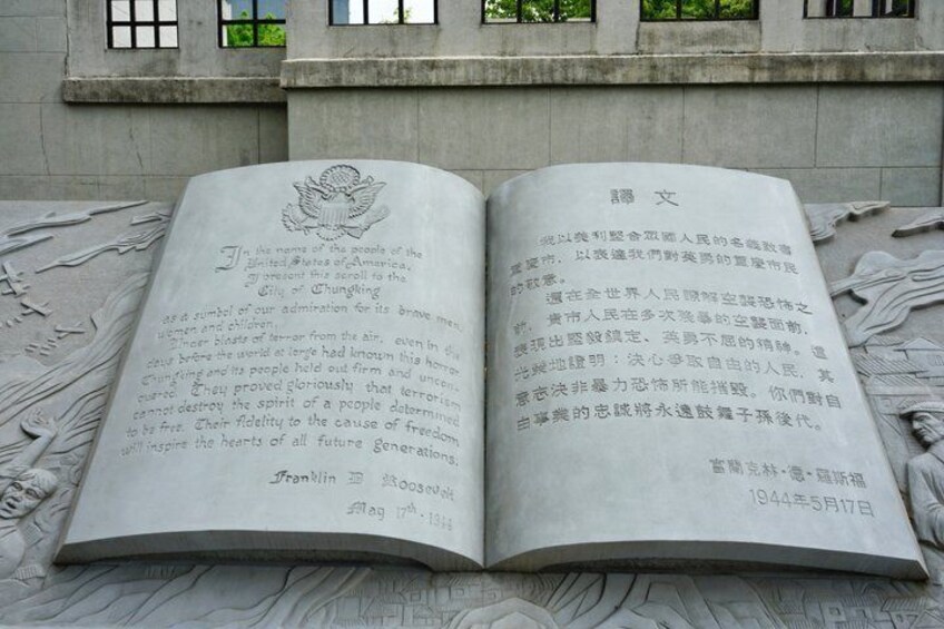 An open book with Chinese text, placed on a stone surface with a statue in the background. 4