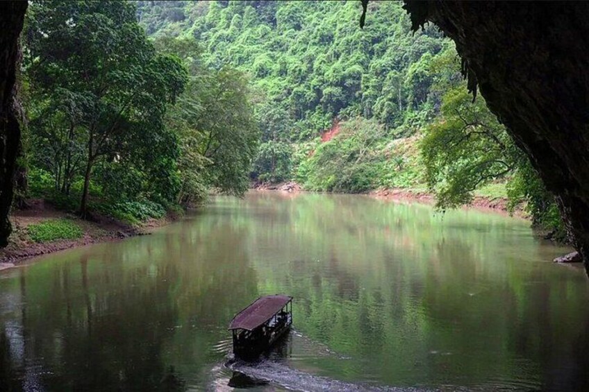 A boat on a calm river surrounded by dense green forest. 5