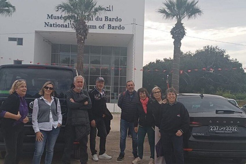 A group of people standing in front of the Musée National du Bardo building. 5