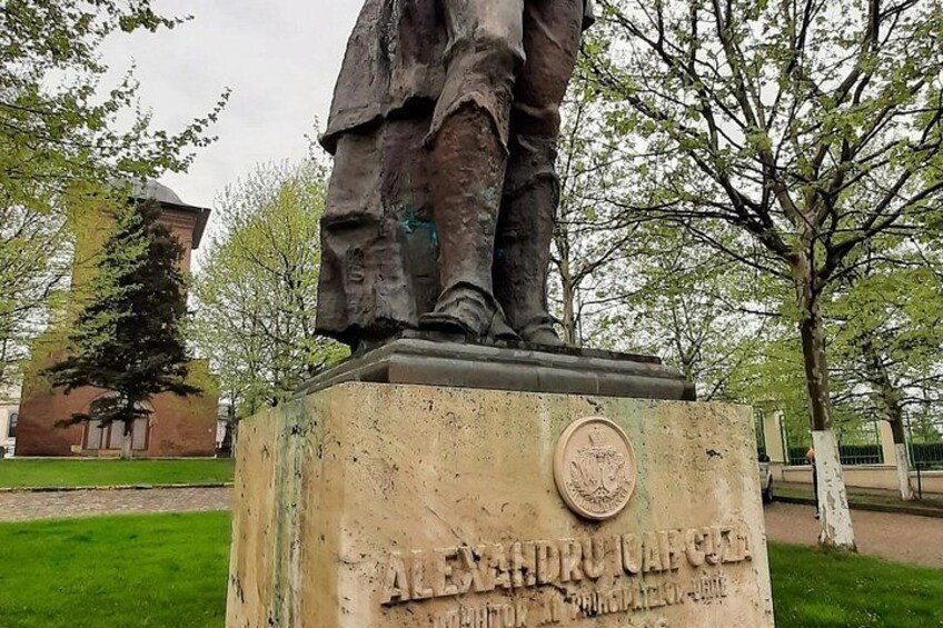 A statue of a man standing on a pedestal with a plaque that reads 'Alexander the Great.' 5