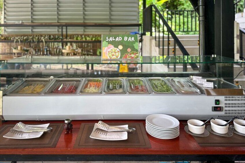 A salad bar with various salad options and condiments. 2