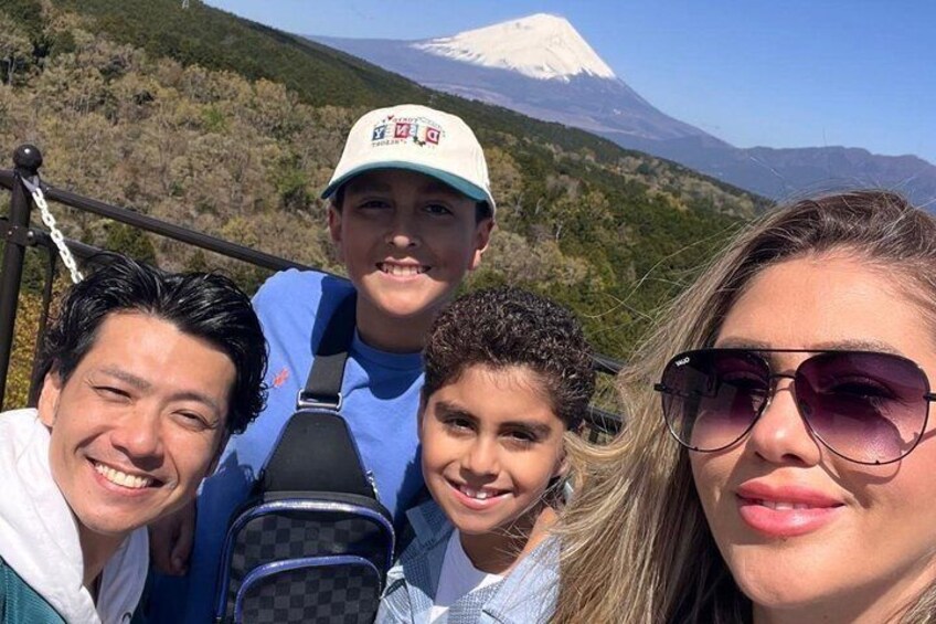A group of people on a mountain trail with a snow-capped peak in the background. 1