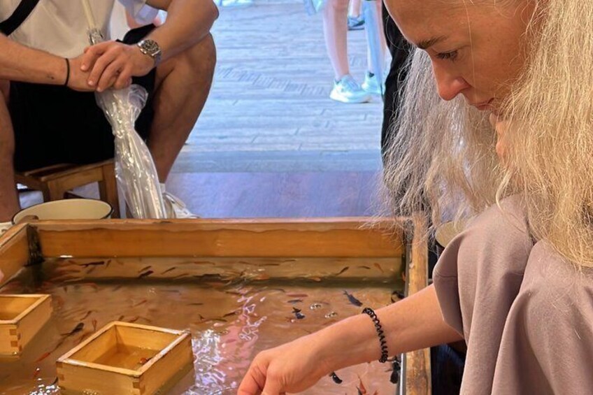 A person handling fish in a wooden trough at a market. 5