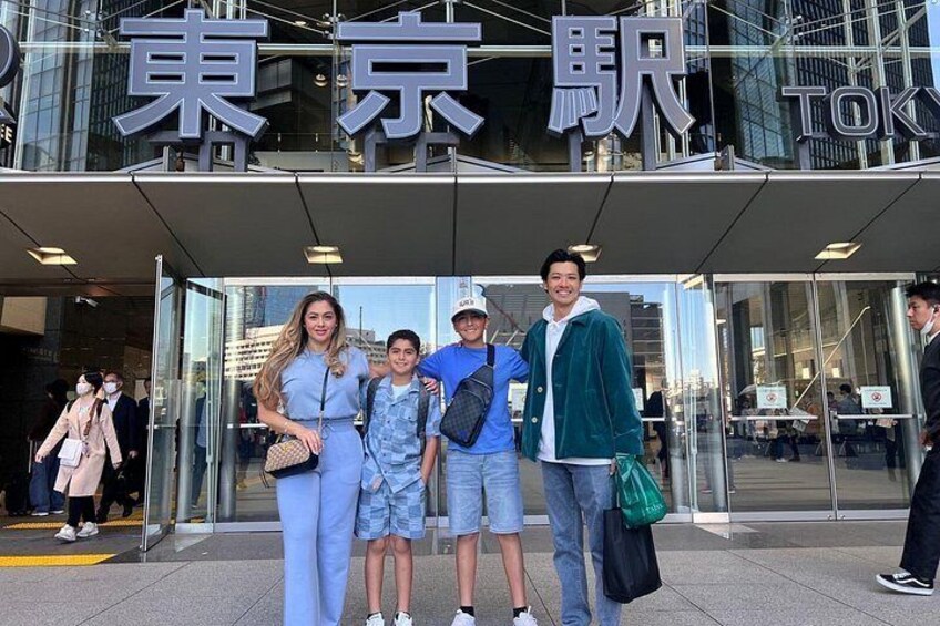 A family in front of a building with large signage, possibly a hotel or office. 2