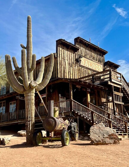 A wooden saloon with a large cactus in front. 5