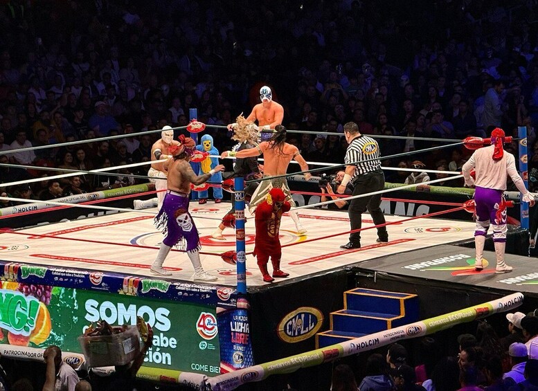 A wrestling ring with a referee and wrestlers in colorful costumes. 3