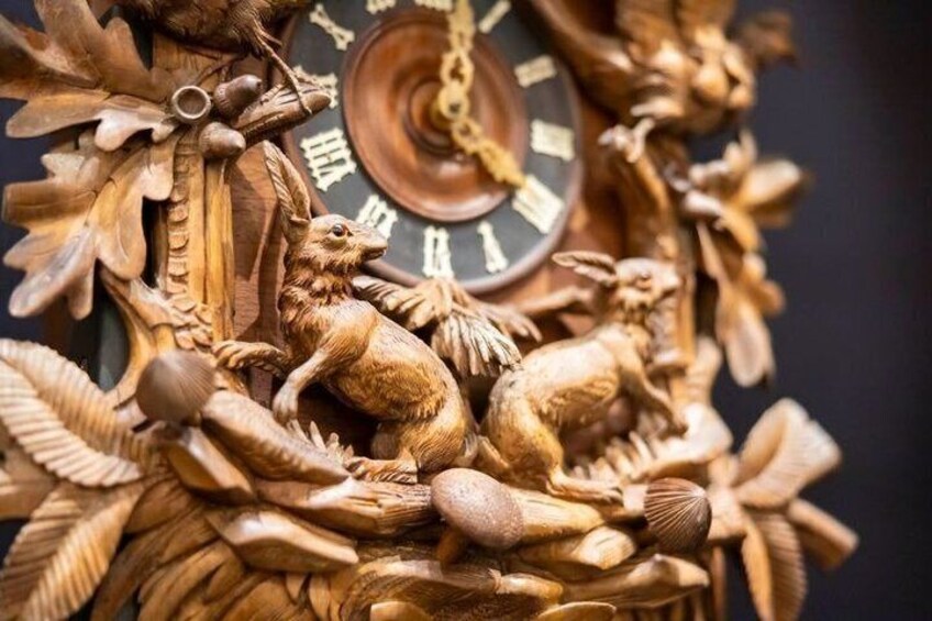 A detailed cuckoo clock with carved animals and a visible clock face. 2