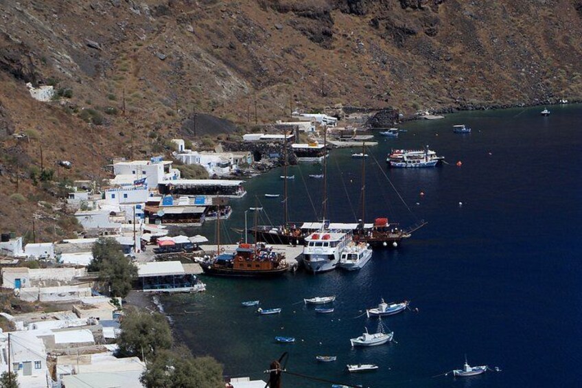 A coastal town with boats docked along the shore, rocky terrain, and buildings. 3