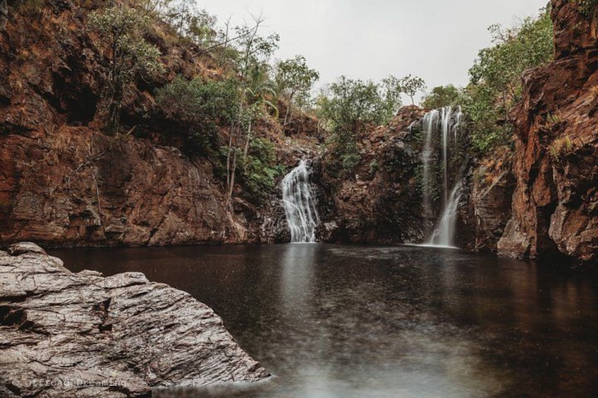 A waterfall in a rocky gorge with a calm pool below. 4