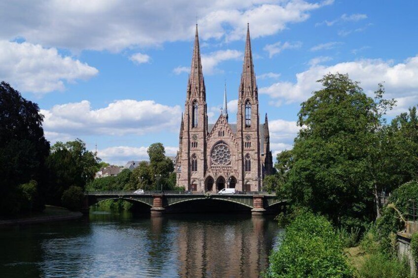 A Gothic cathedral with twin spires, a bridge, and a river. 1