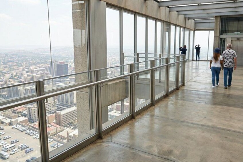 A high-rise building with a glass corridor and a view of a cityscape. 2