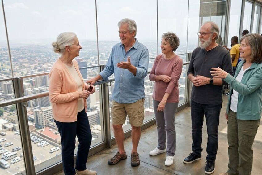 A group of people standing on a glass floor with a cityscape view. 5
