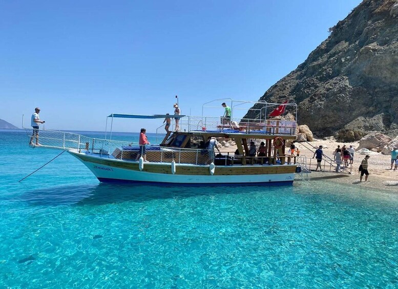 A boat with people on it near a rocky shore. 5