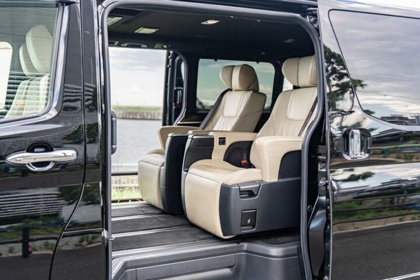 A vehicle interior with beige leather seats and a black door. 3