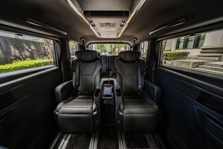 A vehicle interior with two black leather seats, a central console, and a sunroof. 4