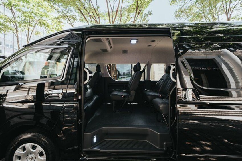A black van with an open door, revealing the interior seating and a visible steering wheel. 2