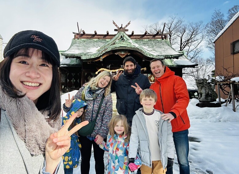 A family in front of a traditional building with a green roof and a lion statue. 2