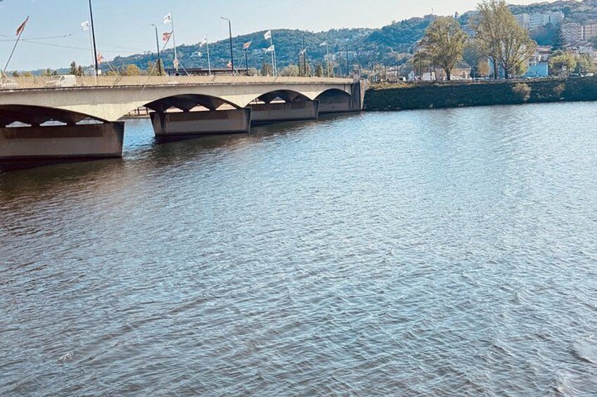 A river with a bridge, flags, and a cityscape in the background. 2