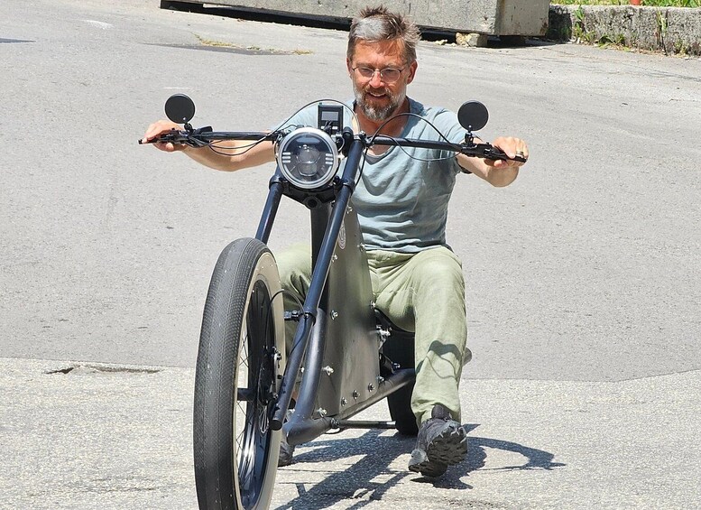 A person sitting on a motorcycle with a sidecar, holding onto handlebars. 5