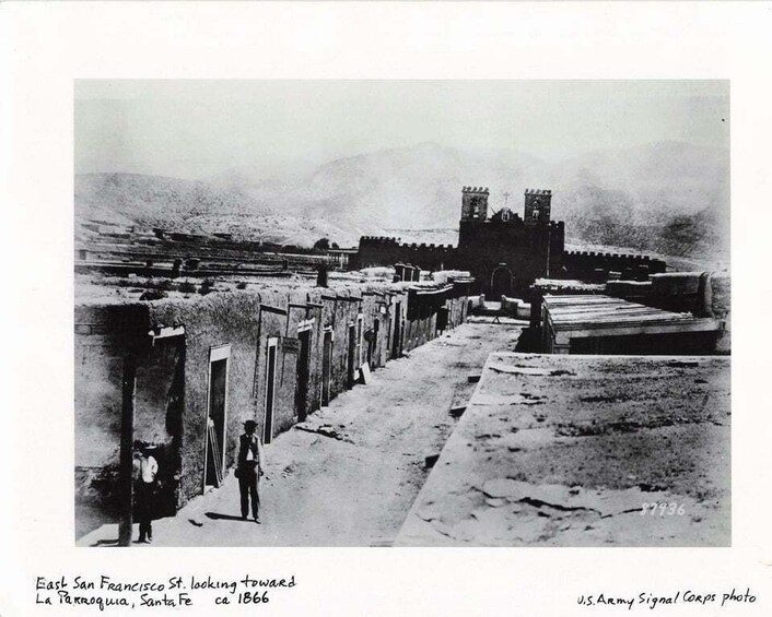 A historical view of East San Francisco St. with a prominent building and a castle-like structure in the background. 3