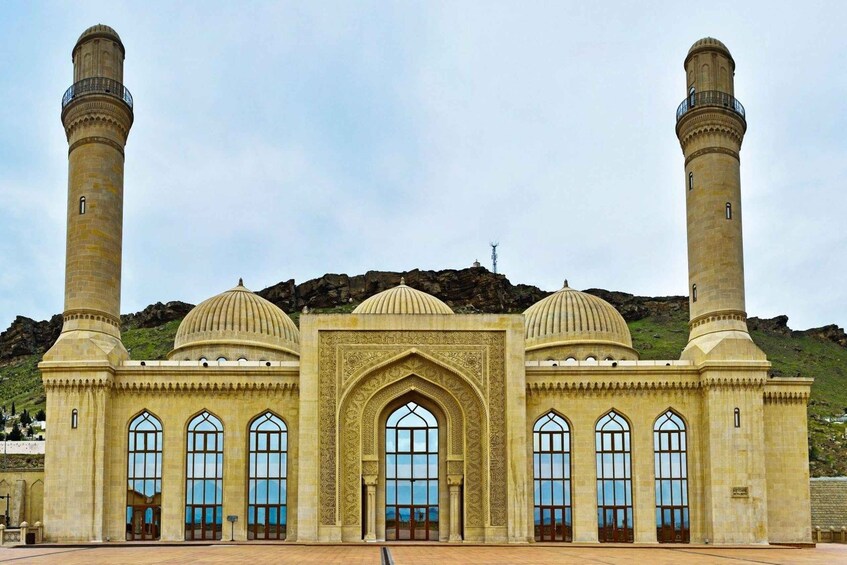 A mosque with two minarets, a large central dome, and arched windows. 2