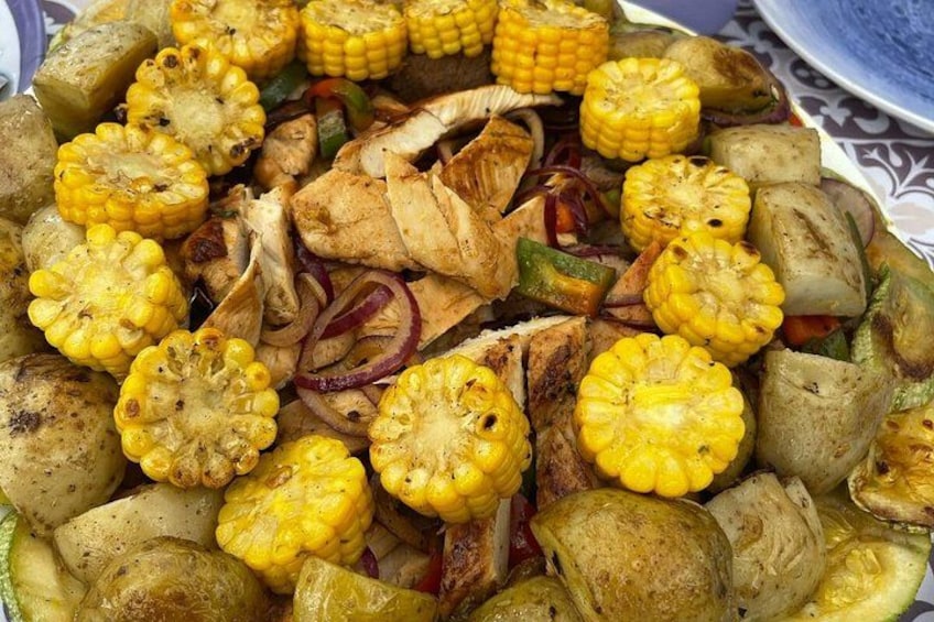 Variedad de verduras a la parrilla, incluyendo mazorca, cebollas y posiblemente calabacín. 3