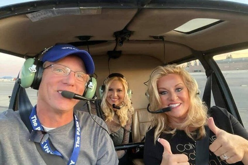 Three people inside a vehicle with a microphone and a lanyard. 1