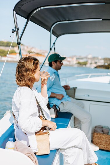 A person in a white shirt and cap on a boat, holding a glass. 3
