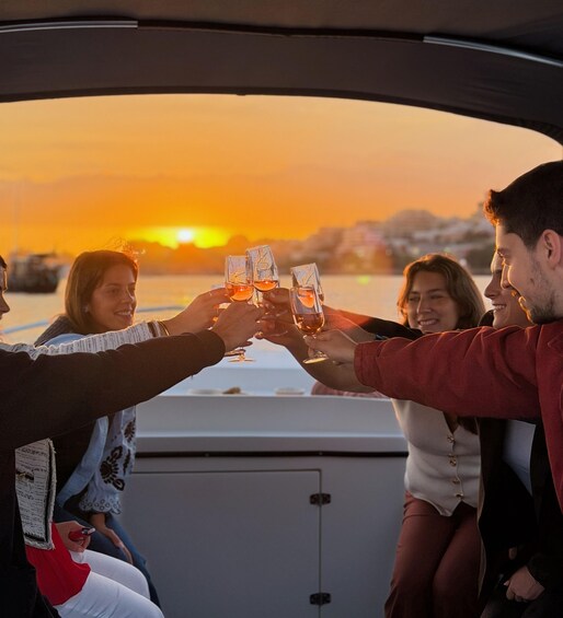 A group of people toasting with drinks inside a vehicle, with a sunset in the background. 1