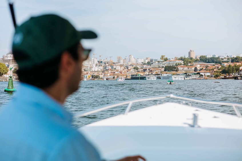 A person on a boat with a cityscape in the background. 4