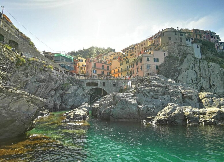 A coastal town with colorful buildings, a rocky shoreline, and a clear blue sea. 4