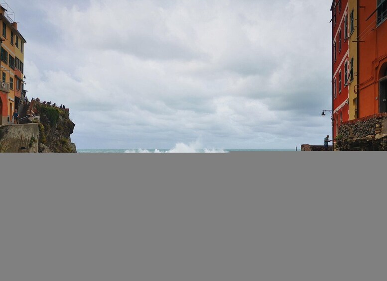 A coastal scene with buildings on either side of a rocky cliff overlooking the sea. 2