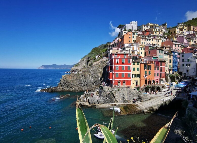 Colorful buildings along a coastal cliff, a rocky shoreline, and the sea. 1