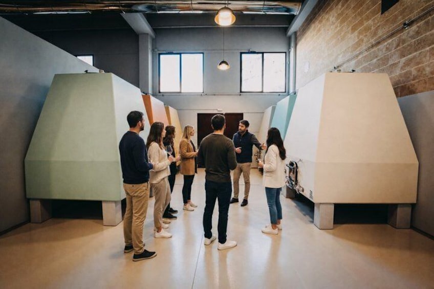A group of people in a modern interior space with geometric shapes and a brick wall. 5